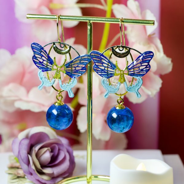 Pendants d’oreilles plaqué or “Papillons d’Océan” – Résine bleue scintillante & double connecteur